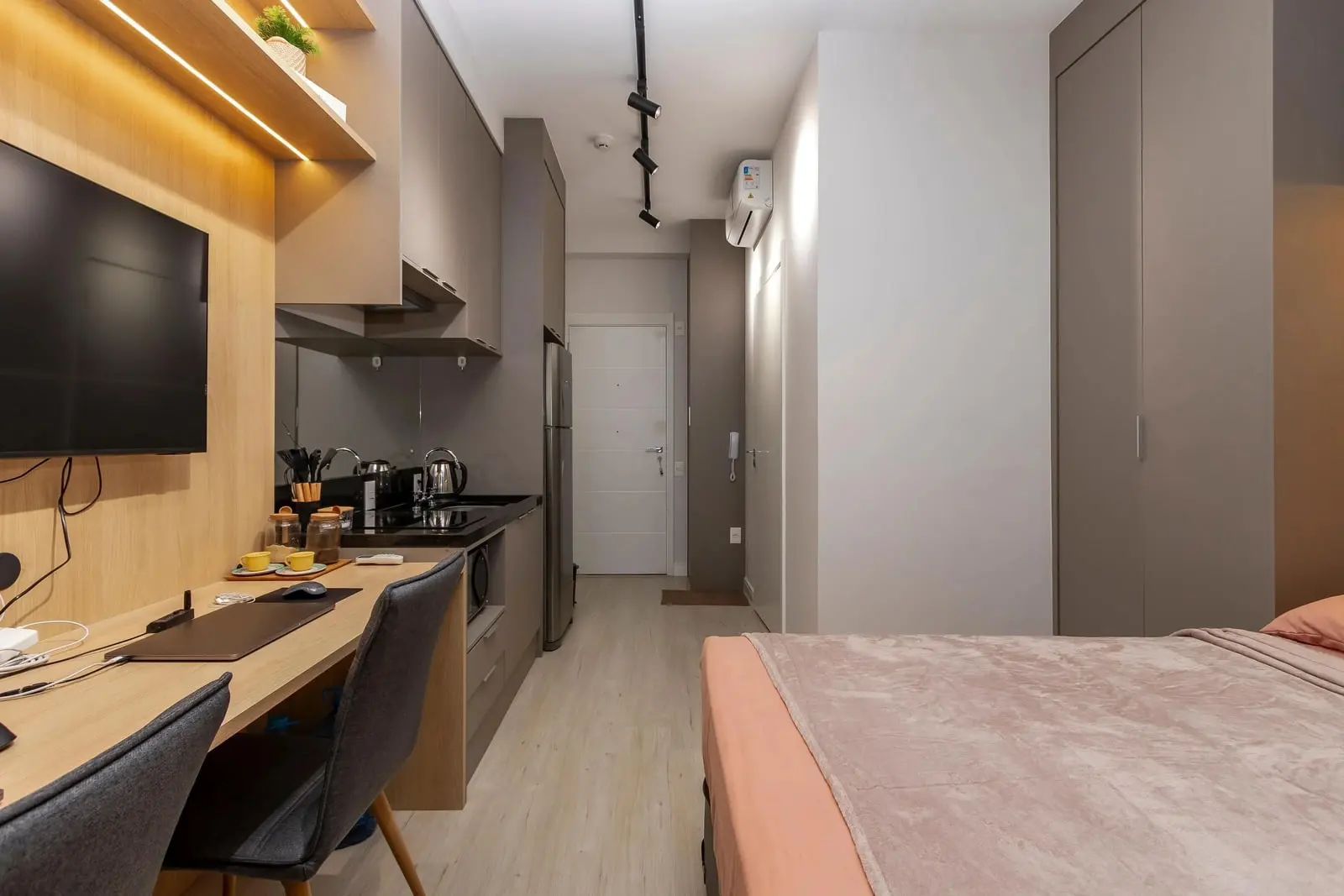 Cozinha do Studio Ipê vista da sacada, com a porta de entrada ao fundo